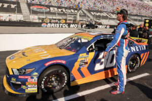 BRISTOL, TENNESSEE - SEPTEMBER 11: Garrett Mitchell, also known as Cleetus McFarland, driver of the #30 Kenetik Ford waves to fans on the grid prior to the ARCA Menards Series Bush's Beans 200 at Bristol Motor Speedway on September 11, 2025 in Bristol, Tennessee. (Photo by Jonathan Bachman/Getty Images)