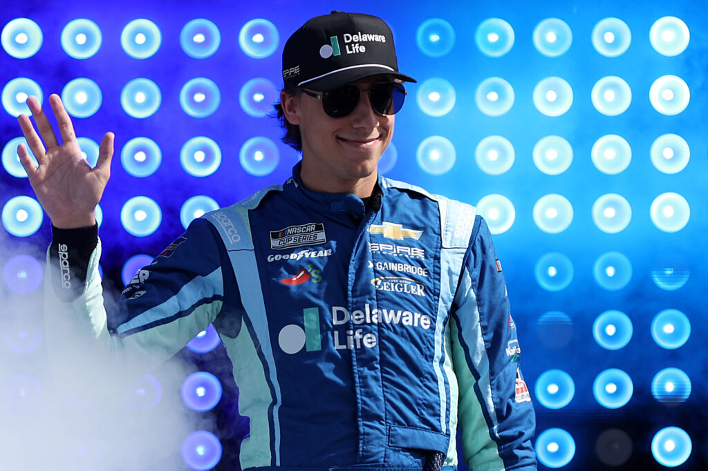 LOUDON, NEW HAMPSHIRE - SEPTEMBER 21: Carson Hocevar, driver of the #77 Delaware Life Chevrolet, waves to fans as he walks onstage during driver intros prior to the NASCAR Cup Series Mobil 1 301 at New Hampshire Motor Speedway on September 21, 2025 in Loudon, New Hampshire. (Photo by Meg Oliphant/Getty Images)