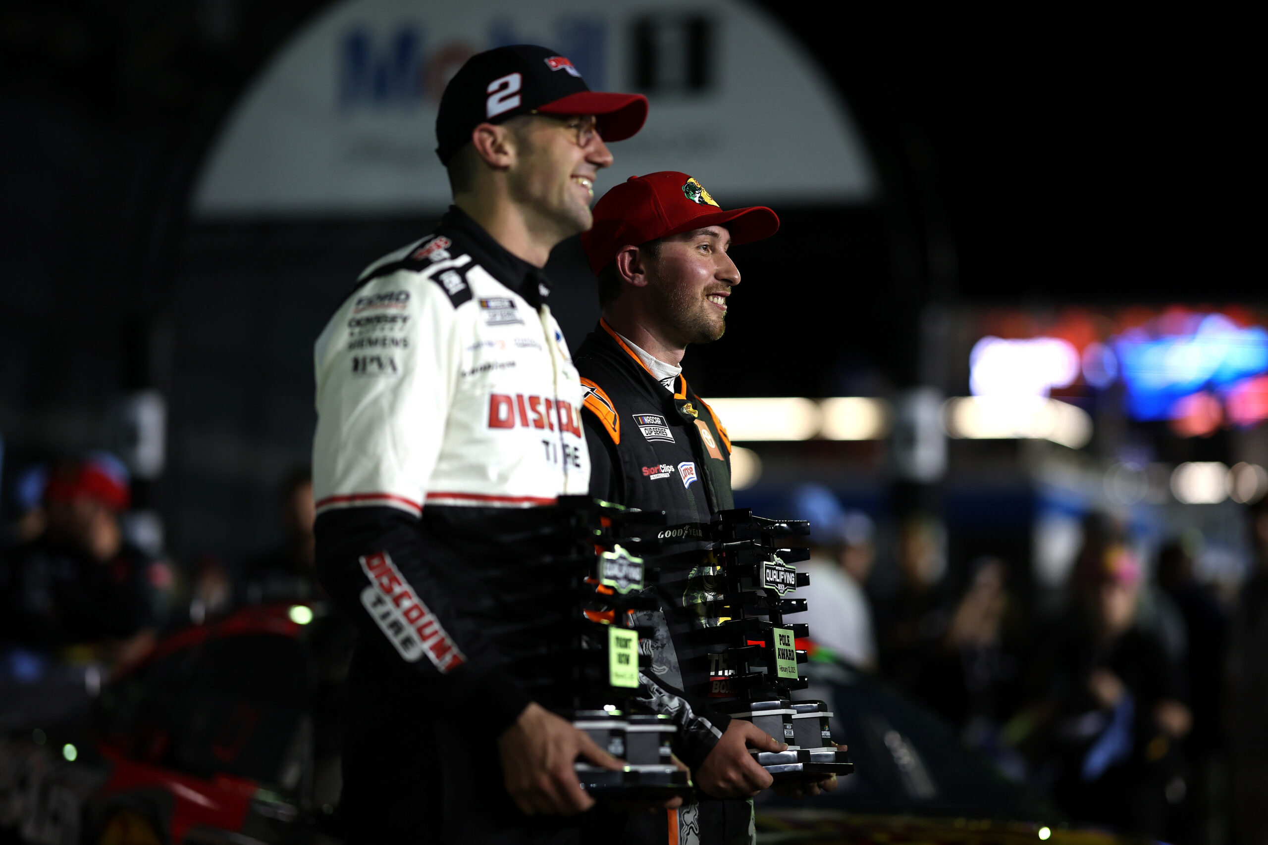 DAYTONA BEACH, FLORIDA - FEBRUARY 12: Pole Award winner, Chase Briscoe, driver of the #19 Bass Pro Shops Toyota (R) and Front Row winner, Austin Cindric, driver of the #2 Discount Tire Ford pose for photos during qualifying for the NASCAR Cup Series Daytona 500 at Daytona International Speedway on February 12, 2025 in Daytona Beach, Florida. (Photo by James Gilbert/Getty Images)
