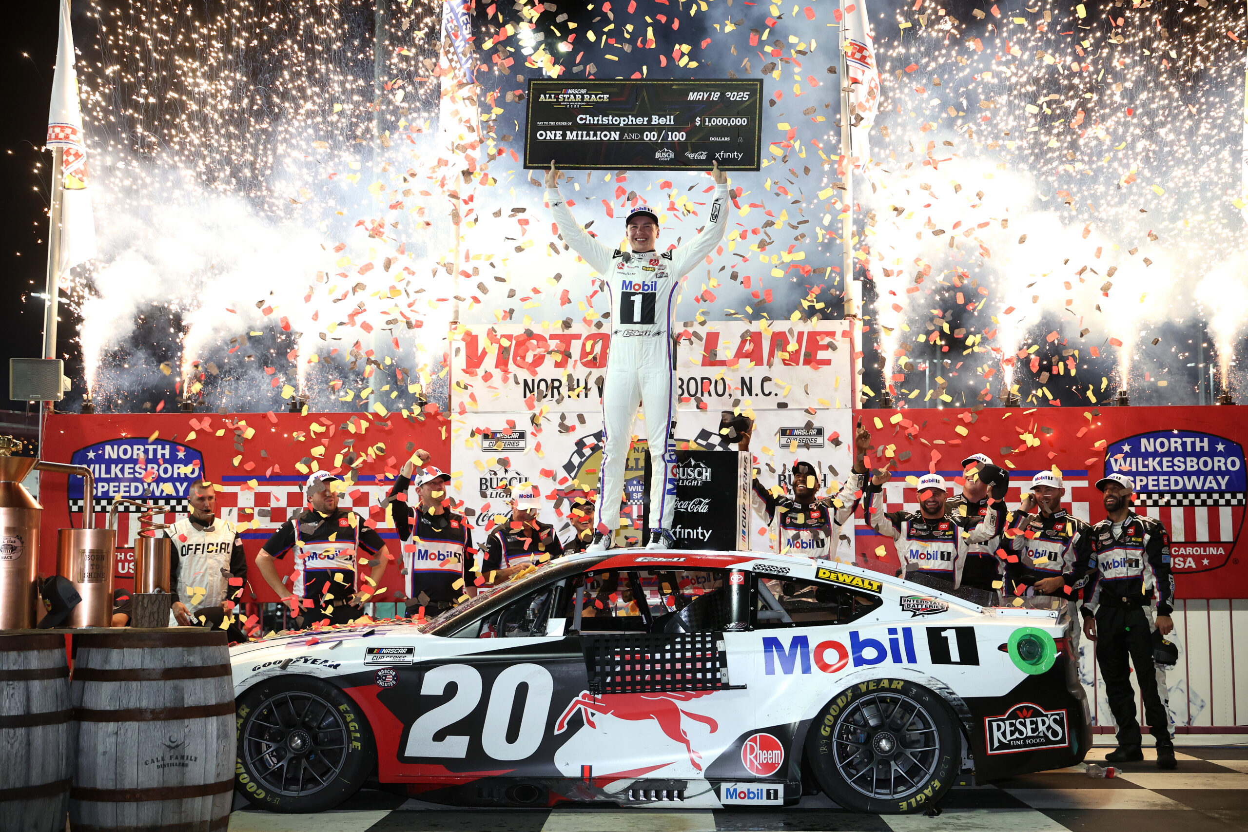 NORTH WILKESBORO, NORTH CAROLINA - MAY 18: Christopher Bell, driver of the #20 Mobil 1 Toyota, poses with the one million dollar check in victory lane after winning the NASCAR Cup Series All-Star Race at North Wilkesboro Speedway on May 18, 2025 in North Wilkesboro, North Carolina. (Photo by James Gilbert/Getty Images)