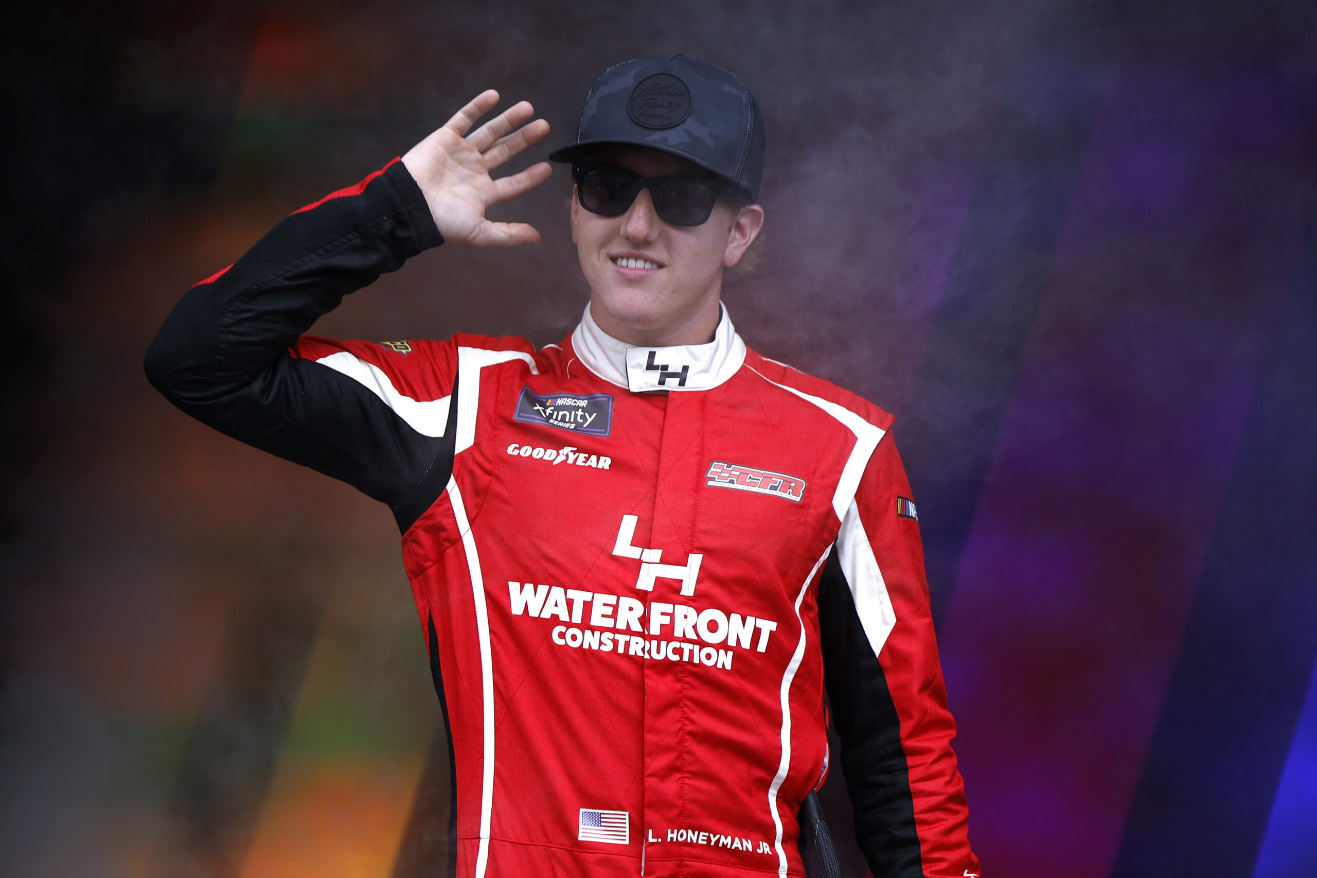 TALLADEGA, ALABAMA - OCTOBER 18: Leland Honeyman, driver of the #70 Wawa Chevrolet, waves to fans as he walks onstage during driver intros prior to the NASCAR Xfinity Series United Rentals 250 at Talladega Superspeedway on October 18, 2025 in Talladega, Alabama.