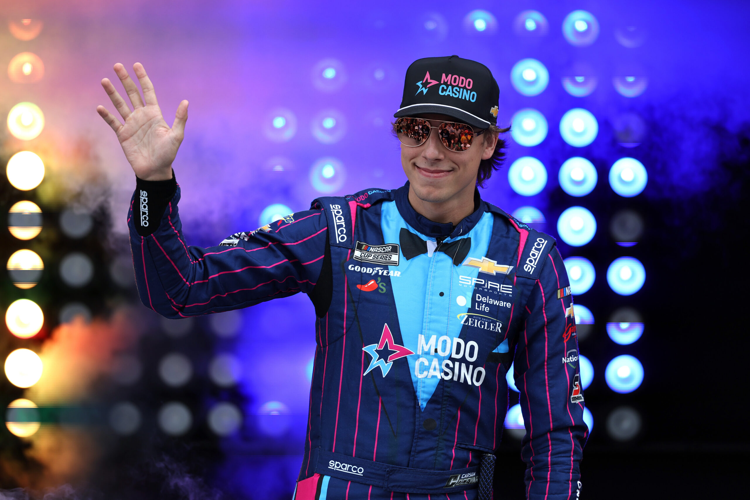 MARTINSVILLE, VIRGINIA - OCTOBER 26: Carson Hocevar, driver of the #77 Modo Casino Chevrolet, waves to fans as he walks onstage during driver intros prior to the NASCAR Cup Series Xfinity 500 at Martinsville Speedway on October 26, 2025 in Martinsville, Virginia. (Photo by David Jensen/Getty Images)