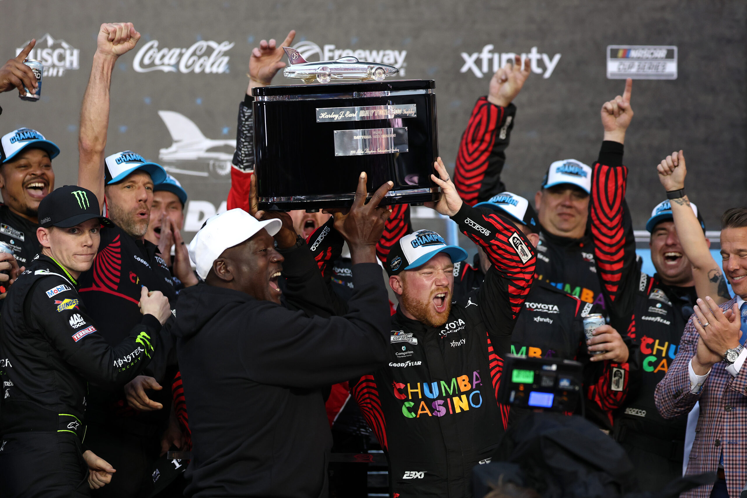 DAYTONA BEACH, FLORIDA - FEBRUARY 15: Tyler Reddick, driver of the #45 Chumba Casino Toyota, and Michael Jordan, NBA Hall of Famer and co-owner of 23XI Racing lift the Harley J. Earl Trophy in victory lane after winning the NASCAR Cup Series Daytona 500 at Daytona International Speedway on February 15, 2026 in Daytona Beach, Florida.