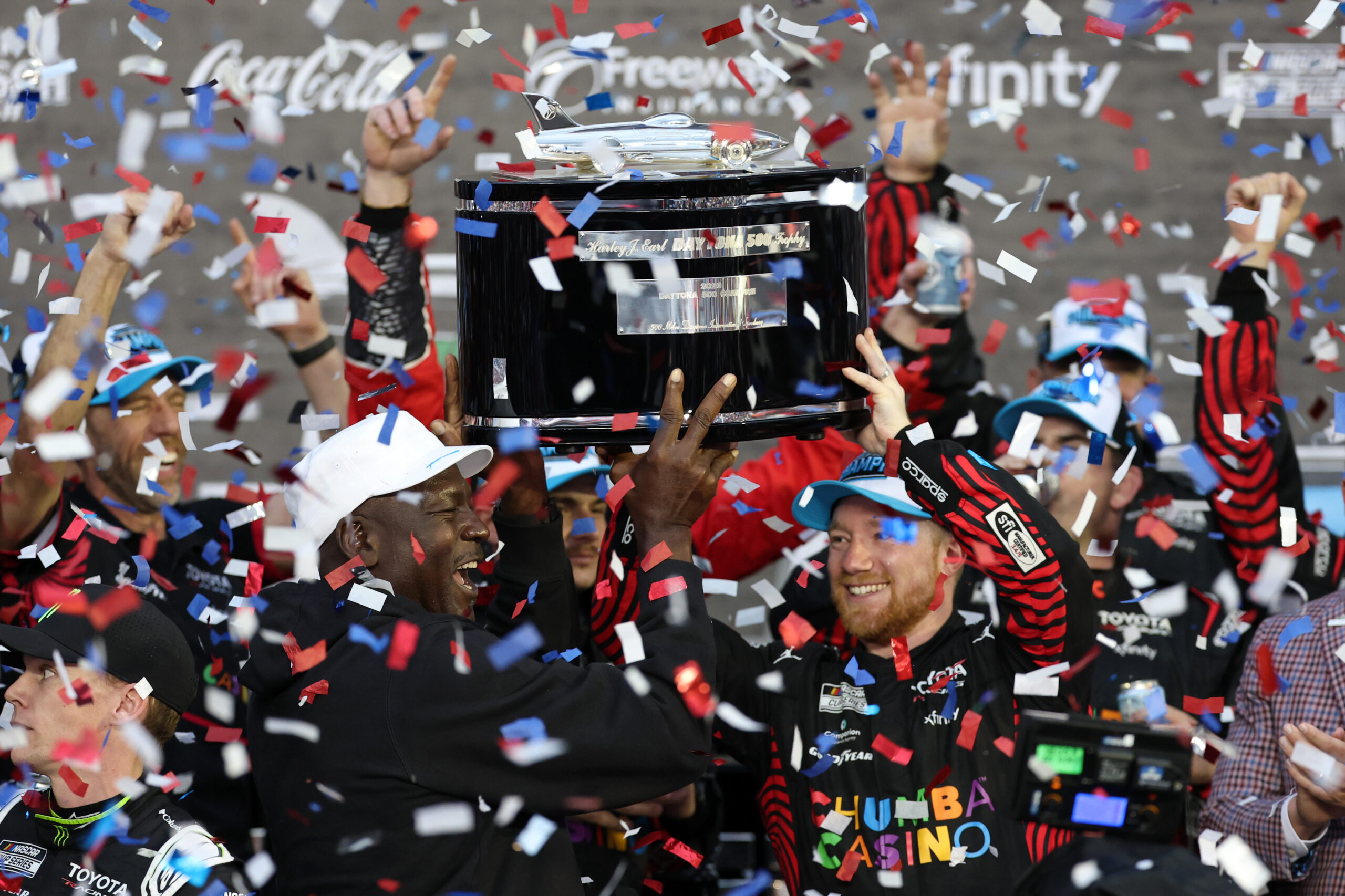 DAYTONA BEACH, FLORIDA - FEBRUARY 15: Tyler Reddick, driver of the #45 Chumba Casino Toyota, and Michael Jordan, NBA Hall of Famer and co-owner of 23XI Racing lift the Harley J. Earl Trophy in victory lane after winning the NASCAR Cup Series Daytona 500 at Daytona International Speedway on February 15, 2026 in Daytona Beach, Florida.