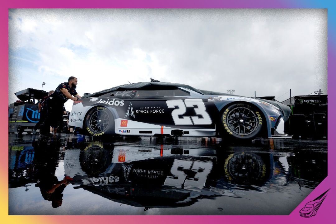 DOVER, DELAWARE - JULY 19: Crew members push the #23 Space Force/Leidos Toyota, driven by Bubba Wallace in the garage area during a weather delay of practice for the NASCAR Cup Series AutoTrader EchoPark Automotive 400 at Dover Motor Speedway on July 19, 2025 in Dover, Delaware. (Photo by Sean Gardner/Getty Images)