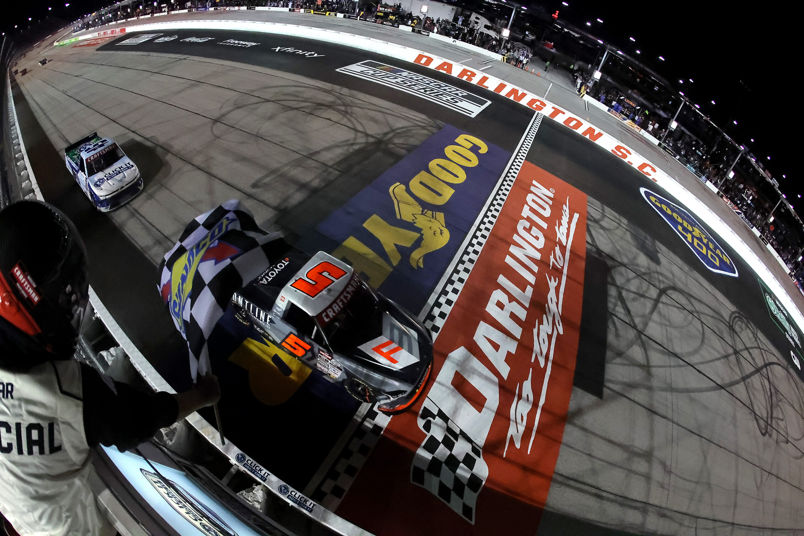 DARLINGTON, SOUTH CAROLINA - MARCH 20: Corey Heim, driver of the #5 Frontline Enterprises Toyota, takes the checkered flag to win the NASCAR Craftsman Truck Series Buckle Up South Carolina 200 at Darlington Raceway on March 20, 2026 in Darlington, South Carolina.