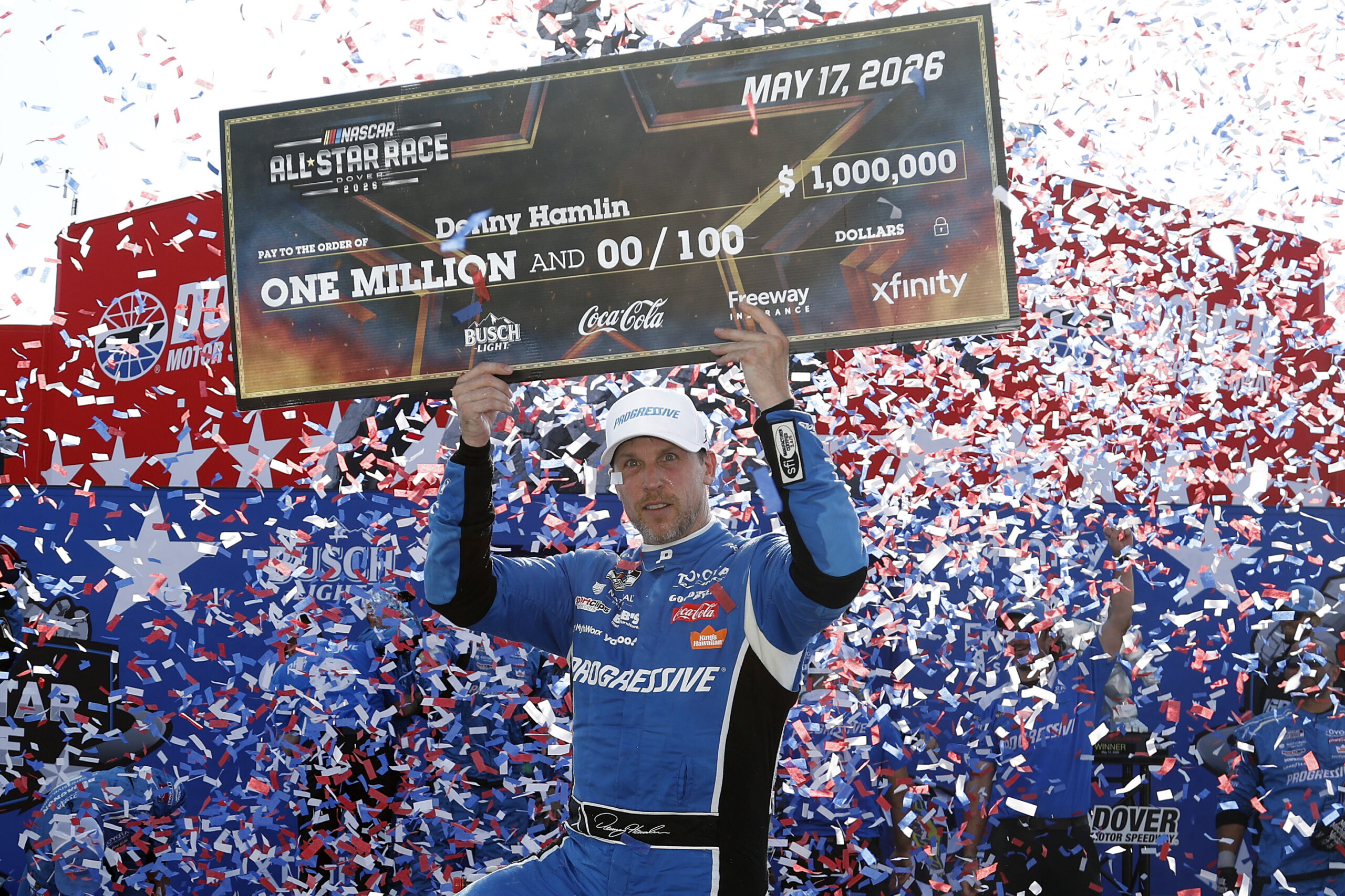 DOVER, DELAWARE - MAY 17: Denny Hamlin, driver of the #11 Progressive Insurance Toyota, poses with the one million dollar check in victory lane after winning the NASCAR Cup Series All-Star Race at Dover Motor Speedway on May 17, 2026 in Dover, Delaware. (Photo by Sean Gardner/Getty Images)